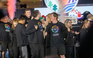 People gathered wearing black t-shirts with logo on them