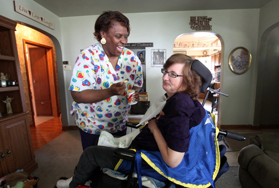 Queen Garner, a home health aide, left, jokes with Susan Werth at Werth's Milwaukee home. A new federal rule taking effect in January will require that most direct care workers are paid at least the federal minimum wage. (Kristyna Wentz-Graff/Milwaukee Journal Sentinel/MCT)