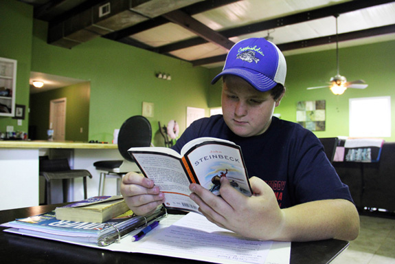 Cody Beck reads a book that was assigned by his teacher. Cody's educational placement has changed numerous times since he was hauled off by police following an incident at school that was determined to be a result of his disability. (Jackie Mader/The Hechinger Report)